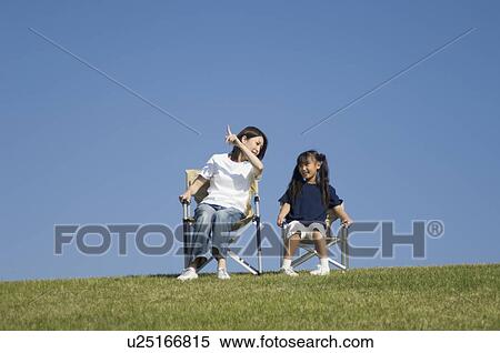 Stock Photography - Mother and daughter sitting in chairs. Fotosearch