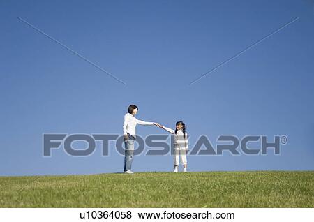 Mother and daughter standing in field View Large Photo Image Stock Photo - Mother and daughter standing in field. Fotosearch