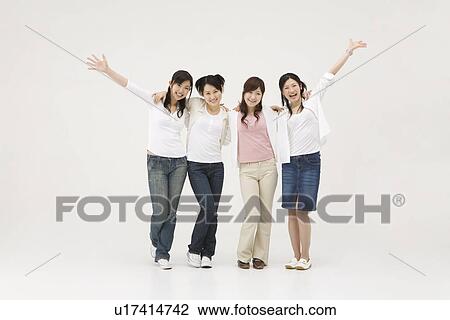 Stock Image - Four young women standing in a line. Fotosearch