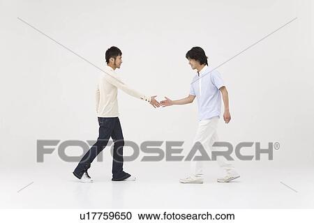 Two young men extending handshake View Large Photo Image Stock Image - Two young men extending handshake. Fotosearch