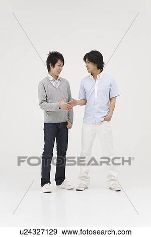 Two young men extending handshake View Large Photo Image Stock Photo - Two young men extending handshake. Fotosearch