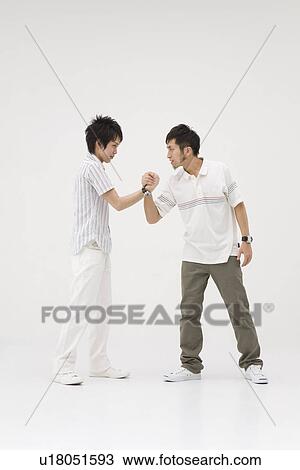 Stock Image - Two young men shaking hands. Fotosearch