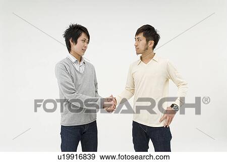 Stock Photo - Two young men shaking hands. Fotosearch