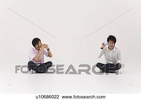 Two young men using string telephone View Large Photo Image Stock Image - Two young men using string telephone. Fotosearch
