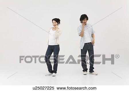 Stock Photography - Two young people talking over mobile phones. Fotosearch