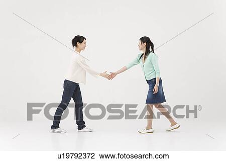 Stock Image - Two young women extending handshake. Fotosearch