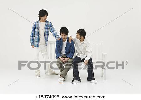 Stock Photograph - Young men comforting their friend. Fotosearch