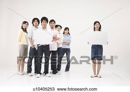 Stock Image - Young people standing with blank message board. Fotosearch