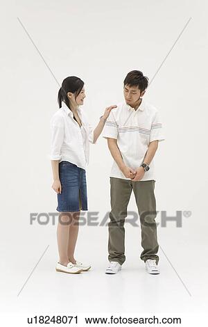 Stock Image - Young woman comforting her boyfriend. Fotosearch