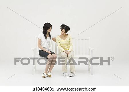 Stock Photography - Young woman comforting her friend. Fotosearch