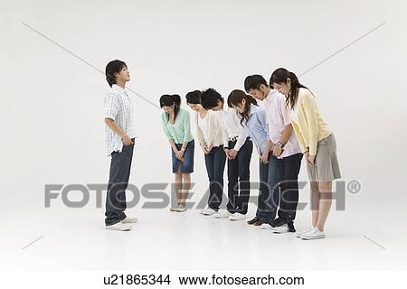 Picture - Group of people bowing to a young man. Fotosearch