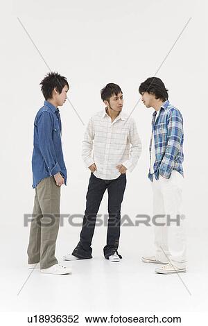 Stock Image - Three young men glaring at each other. Fotosearch