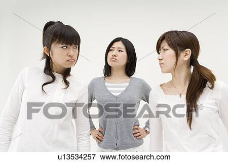 Three young women glaring at each other View Large Photo Image Stock Photo - Three young women glaring at each other. Fotosearch