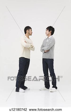 Two young men glaring at each other View Large Photo Image Stock Image - Two young men glaring at each other. Fotosearch