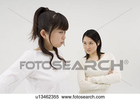 Stock Photography - Two young women glaring at each other. Fotosearch