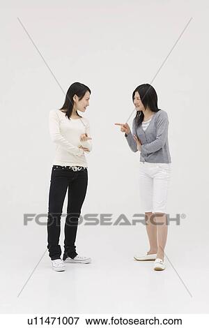 Two young women talking View Large Photo Image Stock Photo - Two young women talking. Fotosearch