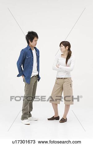 Stock Image - Young couple glaring at each other. Fotosearch