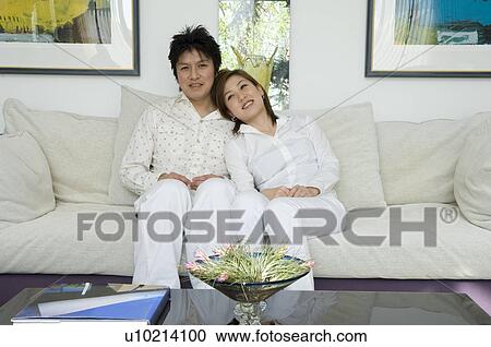 Stock Image - Couple sitting on sofa. Fotosearch