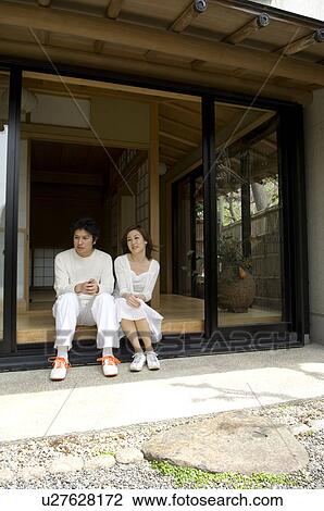Stock Image - Couple sitting on veranda. Fotosearch