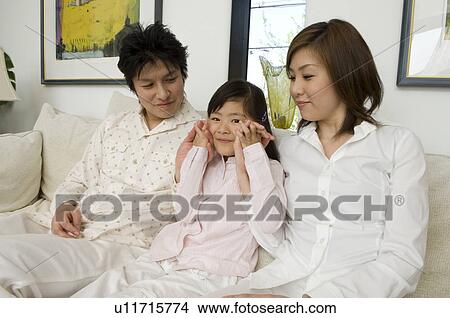 Family sitting on sofa View Large Photo Image Picture - Family sitting on sofa. Fotosearch