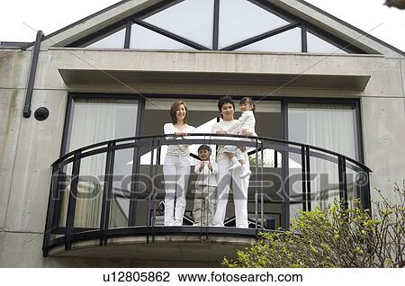 Stock Image - Family standing on balcony. Fotosearch