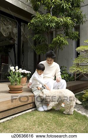 Stock Photograph - Father and son playing with pet dog. Fotosearch