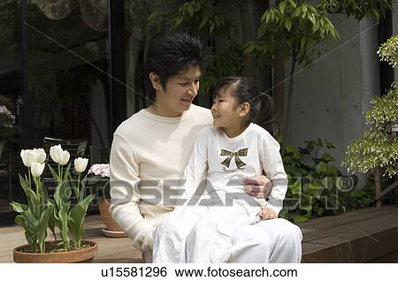 Stock Photograph - Father holding daughter on lap. Fotosearch
