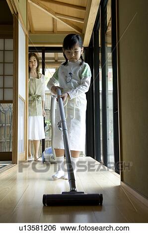 Girl using vacuum cleaner View Large Photo Image Stock Photograph - Girl using vacuum cleaner. Fotosearch