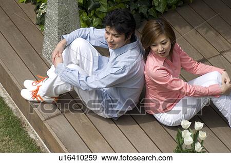 Mid adult couple sitting on wooden deck View Large Photo Image Stock Photo - Mid adult couple sitting on wooden deck. Fotosearch