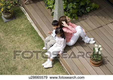 Mother and children sitting on wooden deck View Large Photo Image Stock Photo - Mother and children sitting on wooden deck. Fotosearch