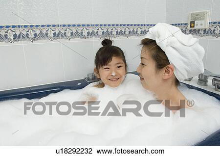 Stock Image - Mother and daughter taking bath. Fotosearch