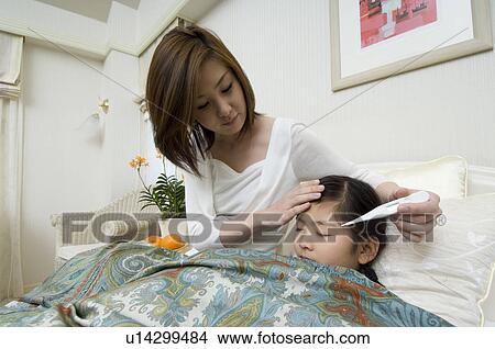 Picture - Mother checking daughter's temperature. Fotosearch