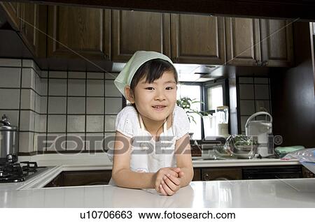 Stock Image - Portrait of a girl wearing apron. Fotosearch