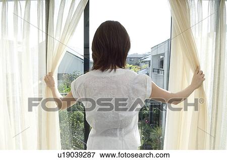 Woman looking through window View Large Photo Image Stock Photo - Woman looking through window. Fotosearch