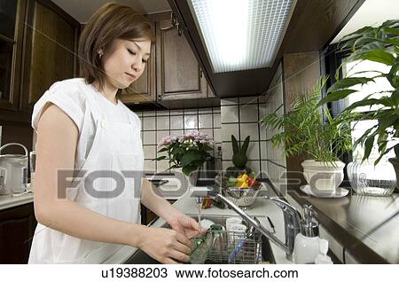 Stock Image - Woman washing dishes. Fotosearch