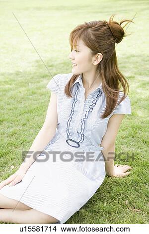 Young woman sitting in park View Large Photo Image Picture - Young woman sitting in park. Fotosearch
