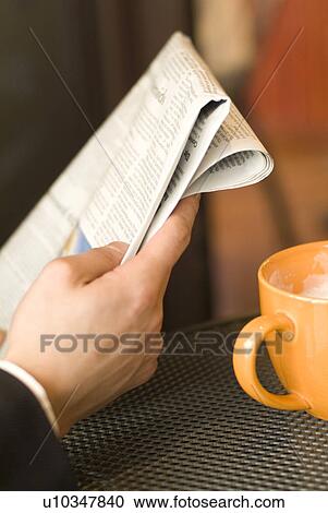 Stock Image - Hand of businessman reading newspaper. Fotosearch