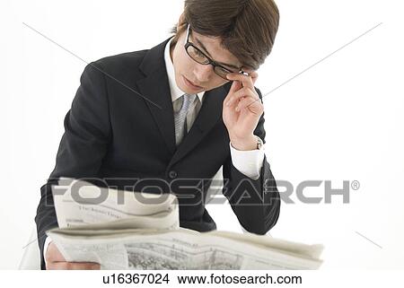 Picture - Young businessman reading newspaper. Fotosearch