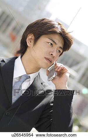 Picture - Young businessman talking over mobile phone. Fotosearch
