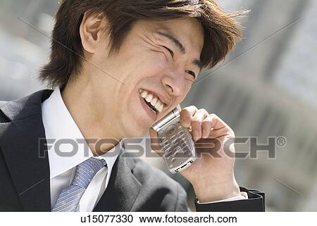 Stock Image - Young businessman talking over mobile phone. Fotosearch