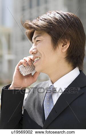 Stock Image - Young businessman talking over mobile phone. Fotosearch