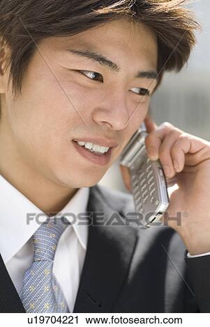 Stock Image - Young businessman talking over mobile phone. Fotosearch
