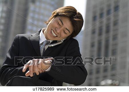 Young businessman talking over mobile phone View Large Photo Image Stock Photo - Young businessman talking over mobile phone. Fotosearch