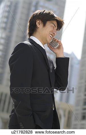 Young businessman talking over mobile phone View Large Photo Image Stock Photo - Young businessman talking over mobile phone. Fotosearch