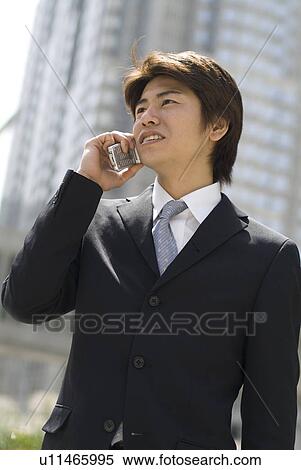 Young businessman talking over mobile phone View Large Photo Image Stock Photography - Young businessman talking over mobile phone. Fotosearch