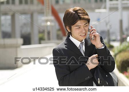 Young businessman talking over mobile phone View Large Photo Image Stock Photography - Young businessman talking over mobile phone. Fotosearch