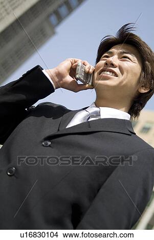 Picture - Young businessman using mobile phone. Fotosearch