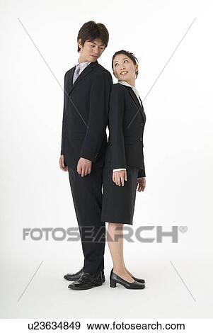 Stock Photo - Young couple standing back to back. Fotosearch