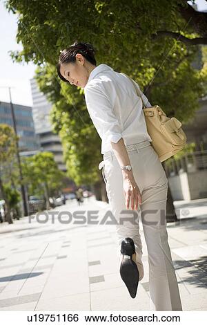 Young woman looking at heels View Large Photo Image Stock Photograph - Young woman looking at heels. Fotosearch
