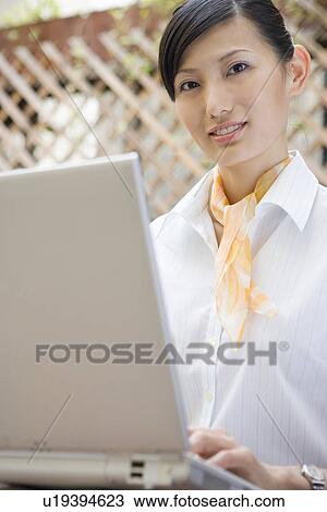 Stock Image - Young woman using computer. Fotosearch